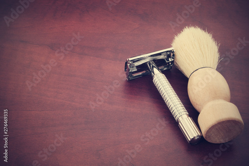 Razor and brush on brown wooden table with room for text