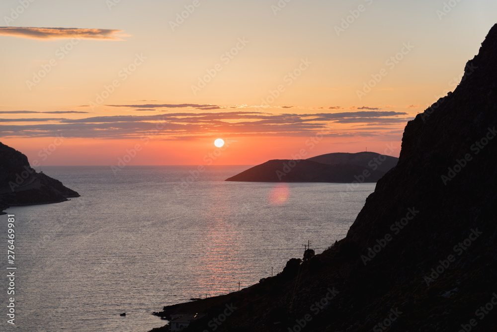The sun setting over the Aegean sea on a beach in Kalymnos, Greece. 