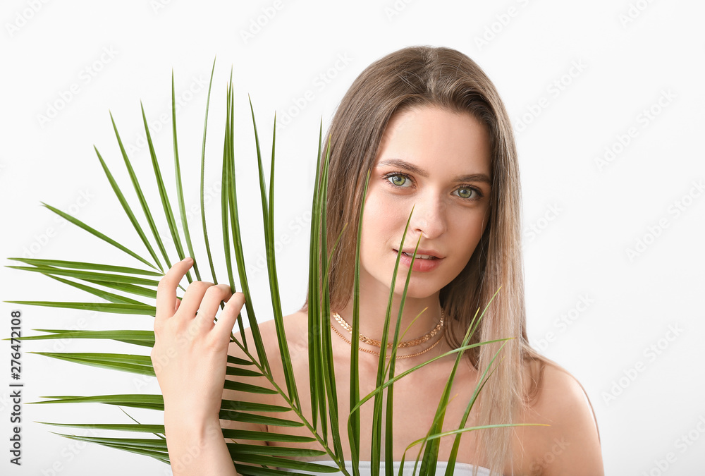 Beautiful young woman with tropical leaf on white background Beautiful young woman with tropical leaf on white background