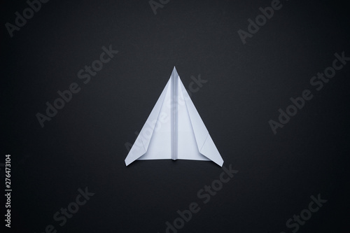 White paper airplane isolated on black background .