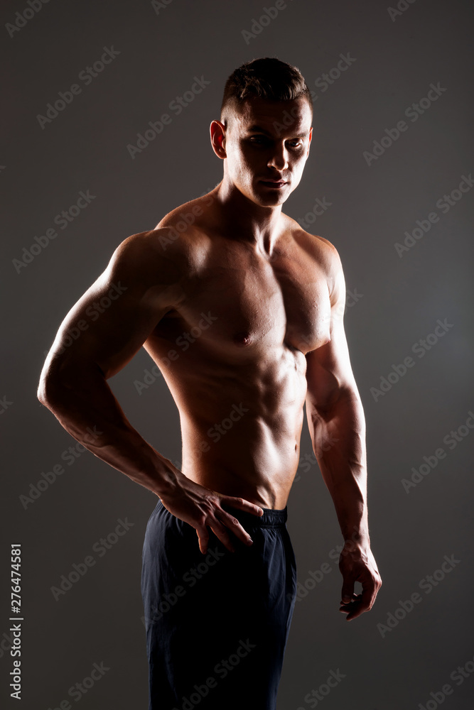 Fototapeta premium Strong, fit and sporty bodybuilder man over black background.