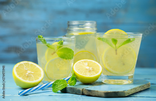 Lemonade or mojito cocktail with lemon and mint on wood background © Poramet