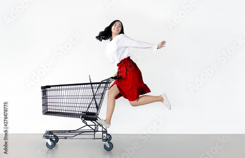 happy asian woman with shopping cart ready for shopping on sale photo