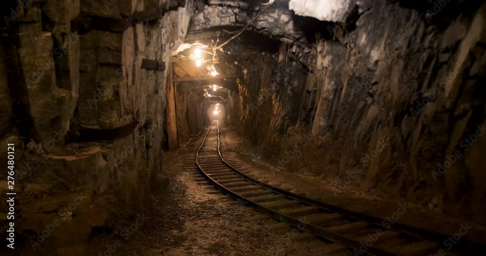 A dimly lit mining shaft. Water dripping onto the rails of the old mining cart. A dimly lit mining shaft. Water dripping onto the rails of the old mining cart.