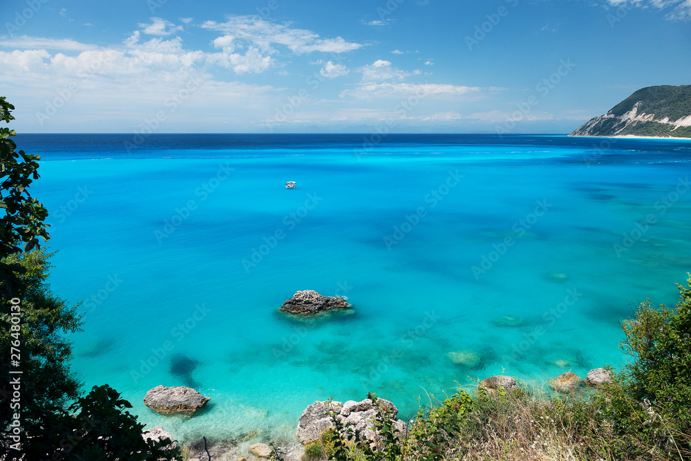 Beautiful tropical lagoon seascape with white boat in blue water. Greece, Lefkada island.