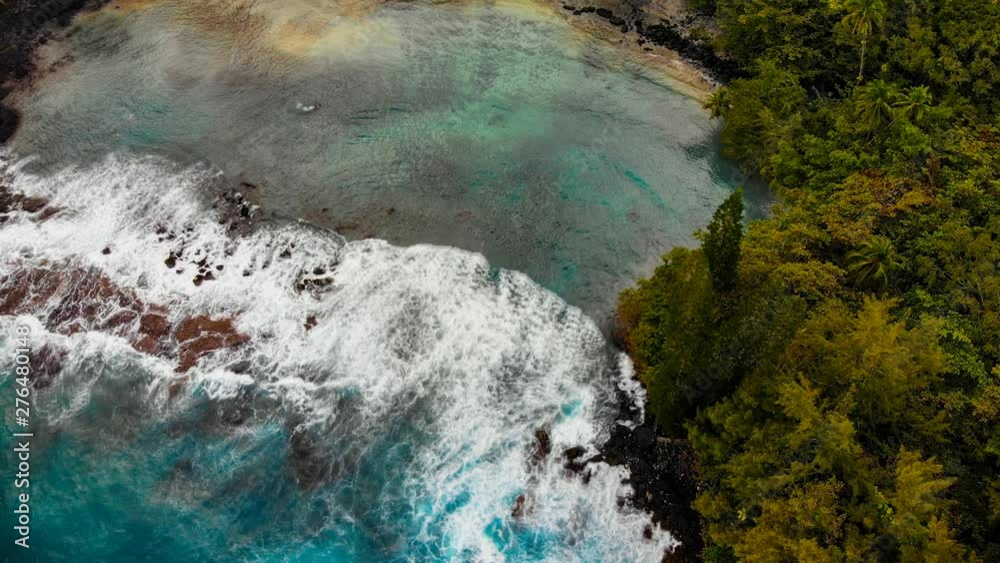 aerial cinemagraph of shipman beach in puna hawaii, a secluded cove that requires a good hike to get there. but the black and white sand mix with the clear water is worth it. aerial cinemagraph of shipman beach in puna hawaii, a secluded cove that requires a good hike to get there. but the black and white sand mix with the clear water is worth it.