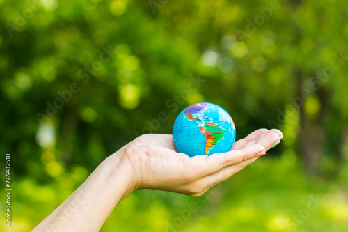 little globe in hand on nature background