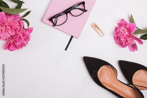 Feminine accessories and beautiful pink peonies on the white background