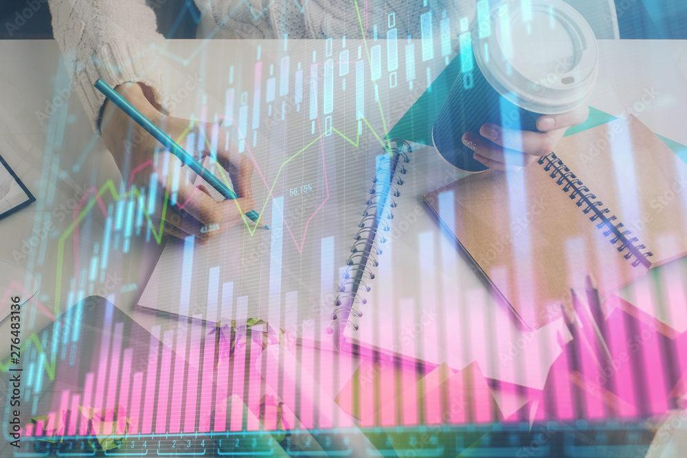 Financial forex graph displayed on hands taking notes background. Concept of research. Multi exposure Financial forex graph displayed on hands taking notes background. Concept of research. Multi exposure