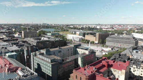 Aerial, pan, drone shot, above buildings and streets, in Kamppi area, overlooking the parlament, toolonlahti, Forum the Railway station and Kiasma, on a sunny day, in Downtown Helsinki, Finland photo