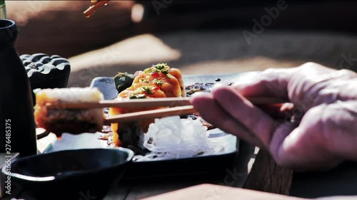 Eating sushi with chopsticks in 
Asia photo