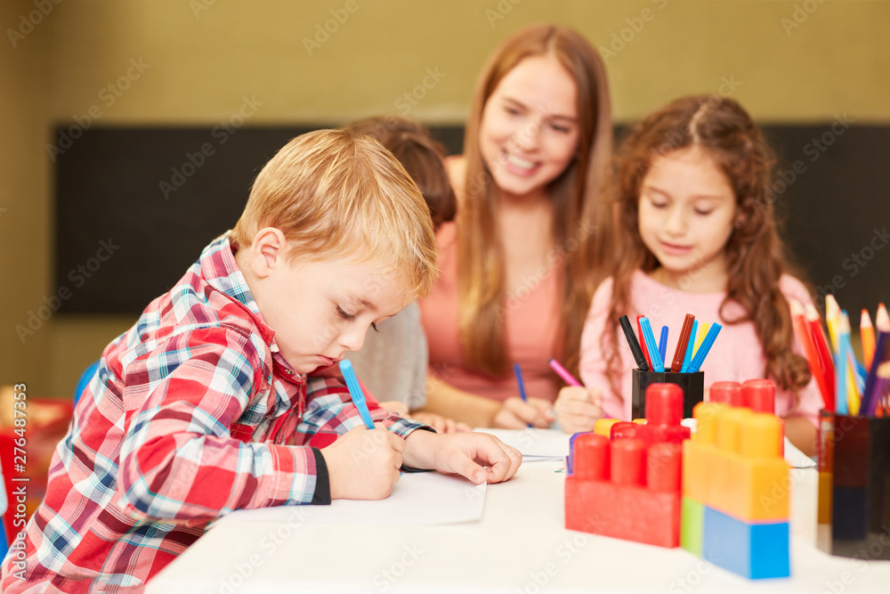 Boy paints concentrated in the painting course of the daycare Boy paints concentrated in the painting course of the daycare