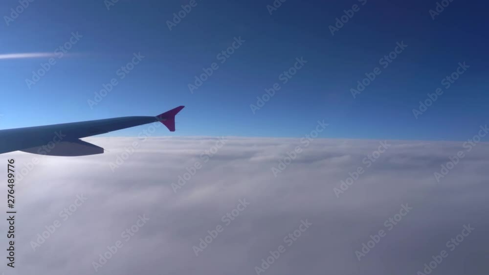 Up in the air, view of aircraft wing silhouette with dark blue sky horizon and cloud background in sun rise time, viewed from airplane window Up in the air, view of aircraft wing silhouette with dark blue sky horizon and cloud background in sun rise time, viewed from airplane window