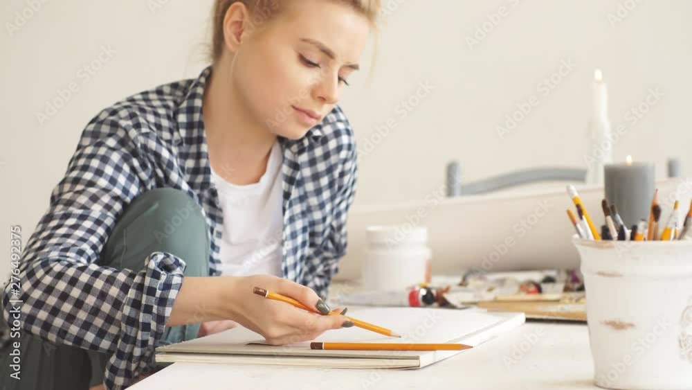Talented blond artist in checked shirt and breeches making up a project in art class. Talented blond artist in checked shirt and breeches making up a project in art class.