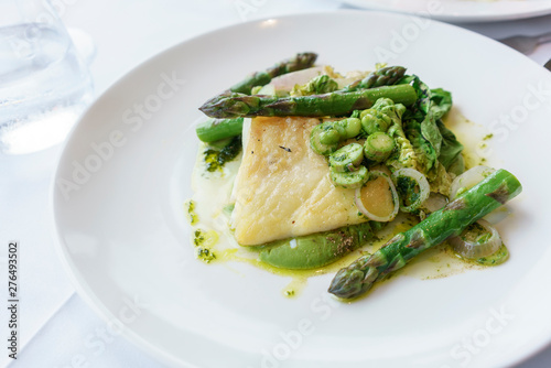 Delicuous fresh Cod cooked with asparagus and broad bean vinaigrette and gem lettuce