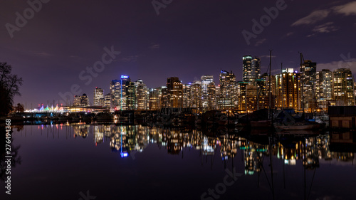 Vancouver  BC   Canada - 13 March 2019  A night long exposure photo of marina inside Burrard Inlet of Vancouver Harbor with many yachts and boats against colorful illuminated city skyline