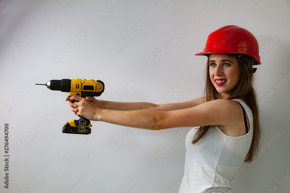 Woman using power driil for work at home