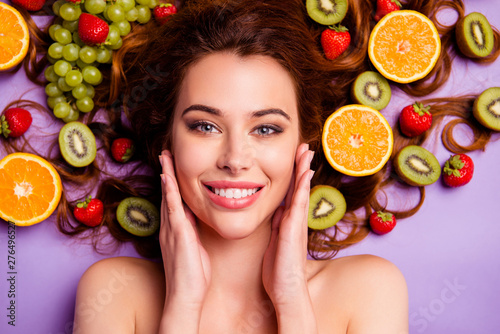 Close-up cropped portrait of nice attractive lovely well-groomed pure perfect shine cheerful cheery feminine wavy-haired lady touching smooth clean clear skin isolated over violet purple background photo