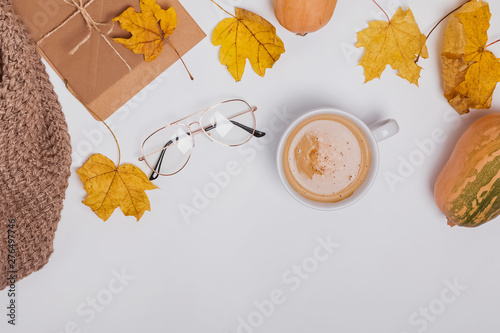 Creative autumncomposition with ciffee and yellow leaves on the white table photo