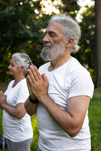Senior couple is practicing meditation in the park