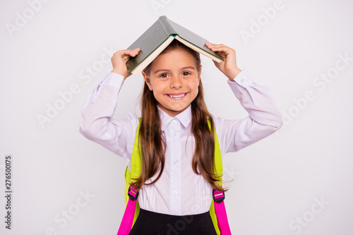 Close-up portrait of her she nice attractive lovely smart clever intelligent funny cheerful cheery pre-teen girl nerd holding book over head like roof isolated over light white grey background