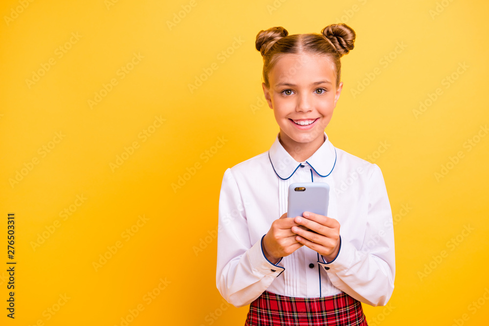 Close-up portrait of nice attractive lovely cheerful cheery pre-teen girl in white shirt using new device gadget app 5g browsing isolated over bright vivid shine yellow background Close-up portrait of nice attractive lovely cheerful cheery pre-teen girl in white shirt using new device gadget app 5g browsing isolated over bright vivid shine yellow background