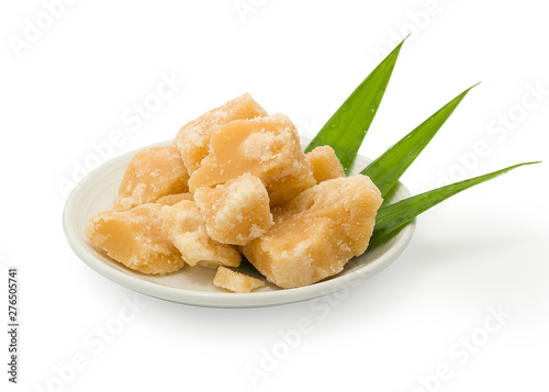 Coconut sugar in ceramic dish on a white background. Jaggery, Palm. photo