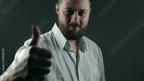 Casual beard business man walks intot he light and smilles with thumbs up for business success photo