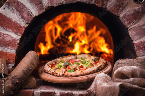 tasty pizza out of oven in restaurant kitchen