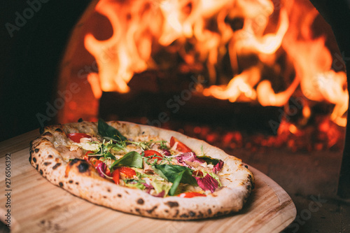 tasty pizza out of oven in restaurant kitchen