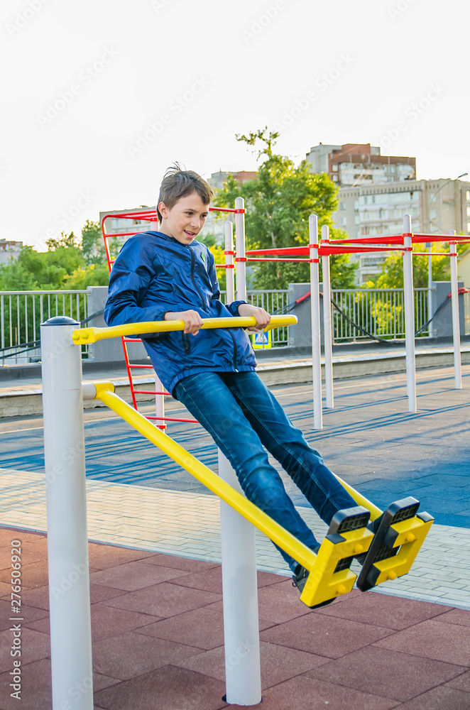 Fototapeta premium Teenager trains on the training apparatus