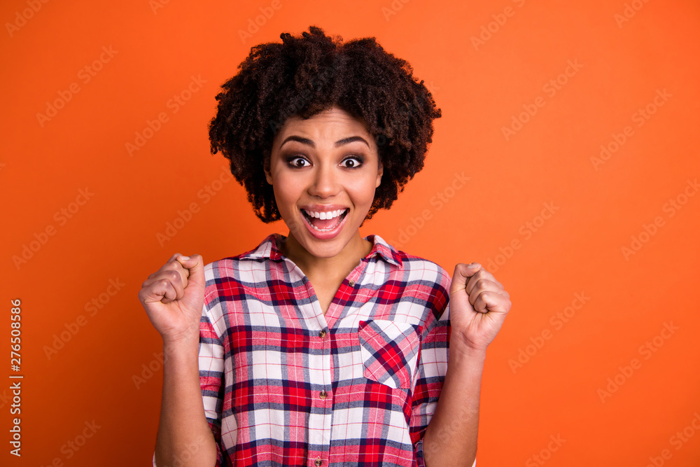 Close-up portrait of her she nice attractive lovely charming cheerful cheery wavy-haired lady wearing checked shirt celebrating winning isolated over bright vivid shine orange background Close-up portrait of her she nice attractive lovely charming cheerful cheery wavy-haired lady wearing checked shirt celebrating winning isolated over bright vivid shine orange background