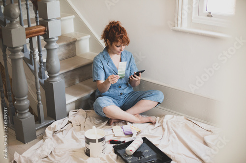 Female ordering paint on smartphone to decorate