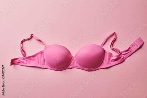 top view of pink brassiere on light pink background, breast cancer concept