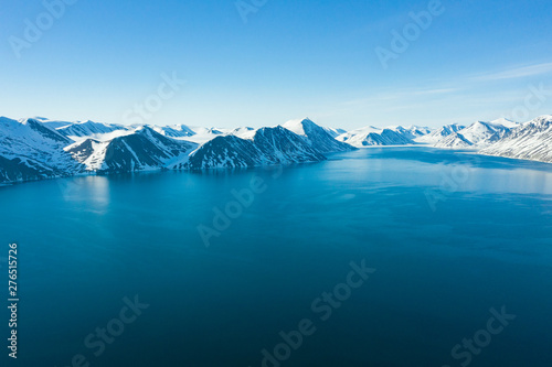 The mountainous sea coast covered with snow in a sunny weather. © Valerii