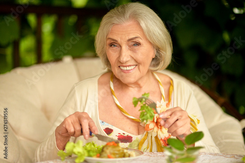 Portrait of cute senior woman eating healthy breakfast
