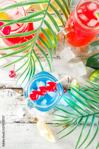 Summer tropical cold drinks. Blue Hawaiian, Tequila sunrise, Sea breeze cocktails over light blue wooden beach background, copy space