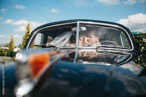 The brides are kissing the car on the wedding day