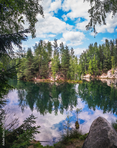 Lake and ancient pines growing between them located in rock city Adrspach, National park of Adrspach, Czech Republic