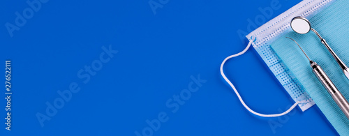 Set of Professional Dentist tools medical equipment isolated on blue background in Dental office. Copy space.- Image