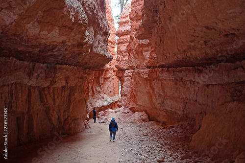 Young woman amidst the hoodoos and rock cliffs of the Wall Street section of the Navajo Loop Trail in Bryce Canyon National Park, Utah.
