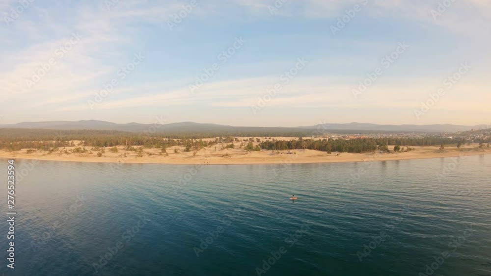 SUP touring. Aerial view of a man stand up paddling on vacation. Tracking shot of man SUP boarding. Orbital SUP touring. Aerial view of a man stand up paddling on vacation. Tracking shot of man SUP boarding. Orbital