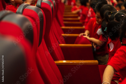 Closeup theatre seats with children in the theater watching the performance