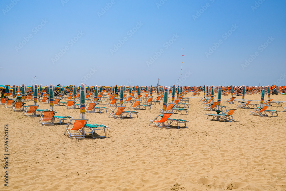 closed umbrellas and deckchairs on an Italian beach