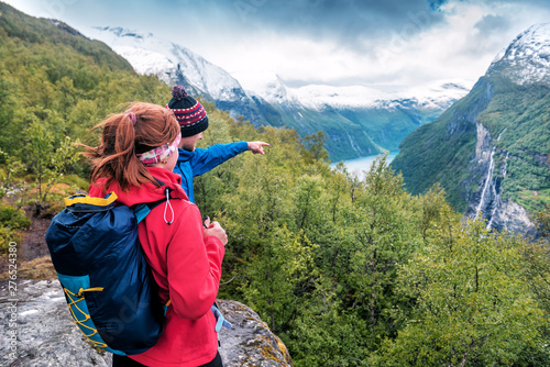 Φωτογραφία tourist guide shows a girl waterfall in the mountains of Norway