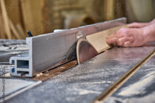 Crop craftsman cutting wood with table saw photo