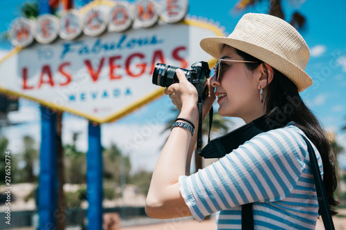 Photography Portrait of beautiful laughing asian chinese girl wearing blue striped t-shirt making photos at summer travel trip