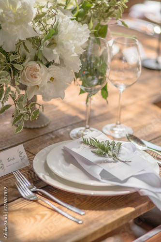 Closeup of a table setting with rustic-style flowers for guests at a wedding or birthday party