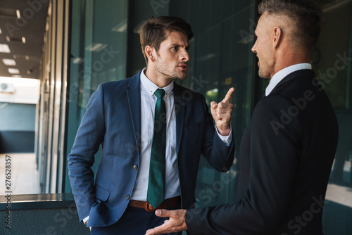 Canvas Print Image of displeased businessmen partners talking and discussing conflict while s