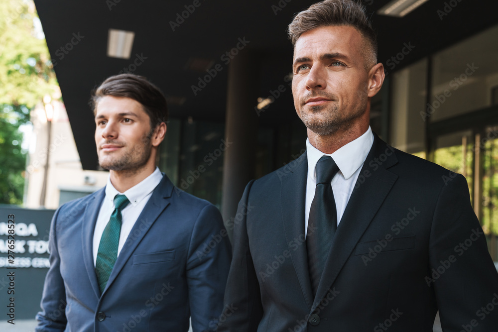 Portrait closeup of two entrepreneur businessmen partners walking together outside job center during working meeting